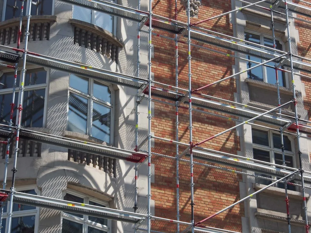 Detalle de una fachada residencial con andamios durante una rehabilitación